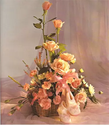 Canasta con 7 rosas rosadas, maule, claveles y zapatitos para niña recién nacida.