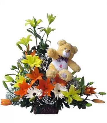 Canasta con 8 ramas de liliums amarillos y naranjas y peluche.