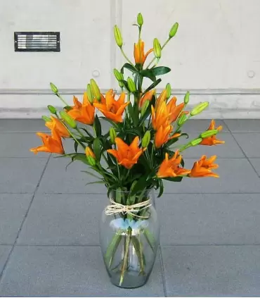 Florero con liliums naranjas, vista complementaria.