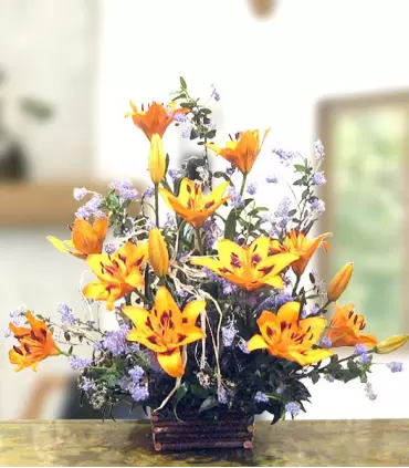 Base de madera con 8 liliums naranjas frescos.